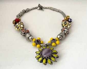 Vintage Rodrigo OTAZU statement necklace with silver tone beads, purple and yellow stone daisy pendant, and colorful rhinestones