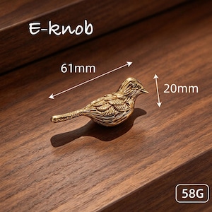 May include: A gold-colored bird-shaped knob labeled E-knob. The bird features detailed wing and feather engravings. Dimension arrows indicate a length of 61mm and a height of 20mm. The object is marked with a weight of 58G.