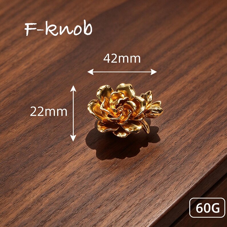 May include: A gold-colored metal cabinet knob shaped like a blooming rose. The knob features the text F-knob, a width of 42mm, a height of 22mm, and a weight of 60G. The metallic surface reflects light, creating highlights and shadows on the petals.