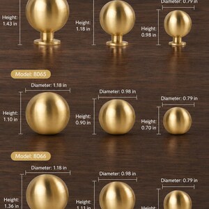 May include: A collection of gold-colored spherical cabinet knobs arranged in three rows labeled Model 8064, 8065, and 8066. Each knob features specific dimensions in inches, with diameters ranging from 0.79 to 1.18 inches and heights from 0.70 to 1.43 inches.