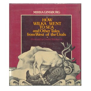 May include: A hardcover book titled How Wilka Went to Sea and Other Tales from West of the Urals by Mirra Ginsburg, illustrated by Charles Mikolaycak. The cover features a maroon background with a reindeer standing over a person in winter gear.