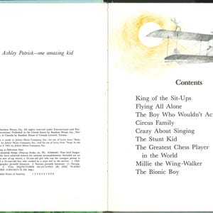 May include: An open book with illustrations and text. The left page reads "To Tarin Ashley Patrick&mdash;one amazing kid." The right page features a drawing of a biplane and the table of contents, including titles like "Flying All Alone" and "The Bionic Boy."