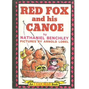 May include: A children's book cover titled "Red Fox and his Canoe" by Nathaniel Benchley, with illustrations by Arnold Lobel. The cover features a red and white title, a drawing of bears and other animals in a canoe, and the text "An I CAN READ Book."