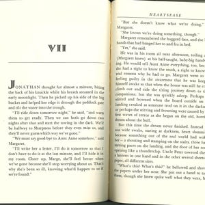 May include: Open book with text on both pages. The left page has a chapter title "VII" and the beginning of a story. The right page has the title "HEARTSEASE" and more text. The pages are aged with a yellowed tone.