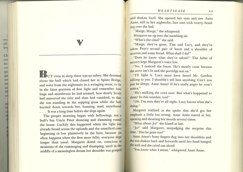May include: Open book with text on cream-colored pages. The left page has a large letter "V" and a paragraph beginning with "But." The right page has text and the title "HEARTSEASE" at the top. The book is open to pages 98 and 99.
