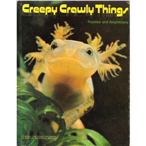 May include: A vintage book cover titled "Creepy Crawly Things" featuring a yellow axolotl with feathery gills. The book is about reptiles and amphibians, with the National Geographic Society logo at the bottom.