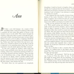 May include: Open book with text on both pages. The left page features the title "Ann" in cursive script and a block of text. The right page continues the text with the page number "115" at the top.
