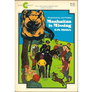 May include: Vintage paperback book cover for "Manhattan is Missing" by E.W. Hildick, illustrated by Jan Palmer. The cover features a large black and orange cat, a police officer on horseback, and a crowd of people. The title is in large, colorful letters.