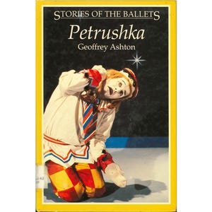 May include: A book cover with a yellow border features the title "Petrushka" from the "Stories of the Ballets" series. The cover art depicts a mime in a white costume with red and yellow checkered pants, kneeling on a stage.