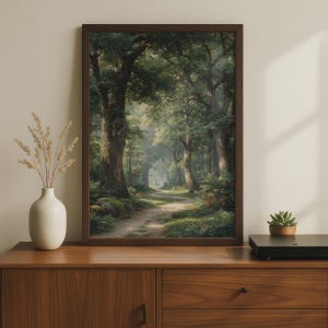 May include: A framed vertical wall art print depicting a dense forest scene with a winding dirt path leading into the distance, surrounded by tall, mossy trees and lush green foliage, encased in a dark brown wooden frame on a wooden surface.