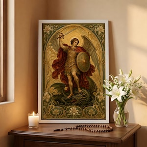 May include: A framed art print depicting an angel in golden armour with wings, holding a sword and shield while standing over a dark dragon. The illustration features a decorative border with lily motifs in shades of green, gold, and red.