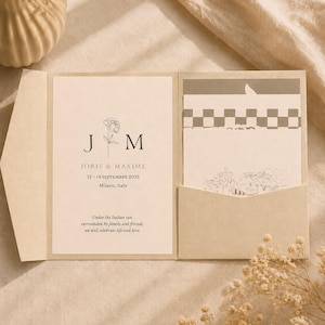 May include: A beige wedding invitation suite with a floral design and the initials "J" and "M". The invitation includes the names Joris & Maxime, the date 12-14 September 2025, and the location, Milano, Italy. The suite also includes a pocket for additional cards.