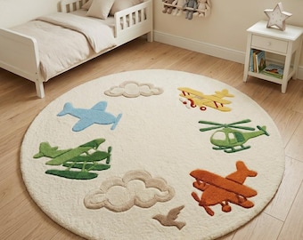 May include: A round, cream-coloured area rug featuring a tufted design of various aircraft including a light blue aeroplane, a dark green biplane, a yellow biplane, a green helicopter, and an orange aeroplane, interspersed with beige clouds and a bird.