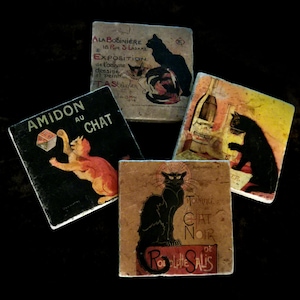 May include: A collection of five square ceramic coasters featuring vintage cat-themed art. The coasters showcase illustrations with cats, text, and a variety of colors, including black, red, and yellow. The coasters are arranged on a dark surface.
