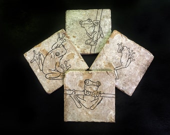May include: Set of four square stone coasters with black line drawings of frogs on each coaster.