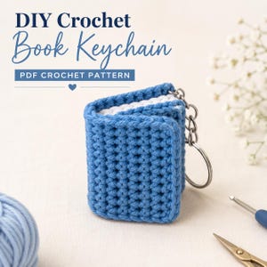 May include: A blue crocheted book keychain with white pages and a metal ring attachment. The text DIY Crochet Book Keychain PDF CROCHET PATTERN is visible at the top. The item is made of yarn and features a textured stitch pattern throughout.