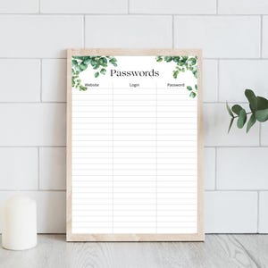 May include: A rectangular password log sheet in a light wood frame featuring a white background with green eucalyptus leaf illustrations at the top corners. The page includes the header Passwords and three columns labelled Website, Login, and Password.