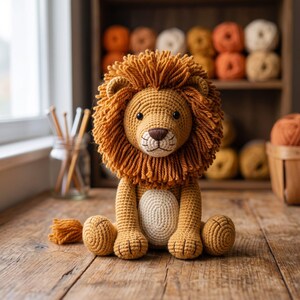 May include: A handcrafted crochet lion toy featuring a golden-yellow body, a thick textured mane made of yarn, and a cream-colored belly patch. The stuffed animal has dark brown embroidered eyes and a nose, sitting in an upright position.