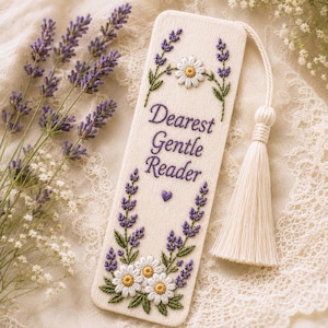 May include: A rectangular fabric bookmark in off-white featuring purple embroidered lavender sprigs, white daisy flowers with yellow centers, and the text "Dearest Gentle Reader" in purple thread, finished with a small purple heart and a cream tassel.