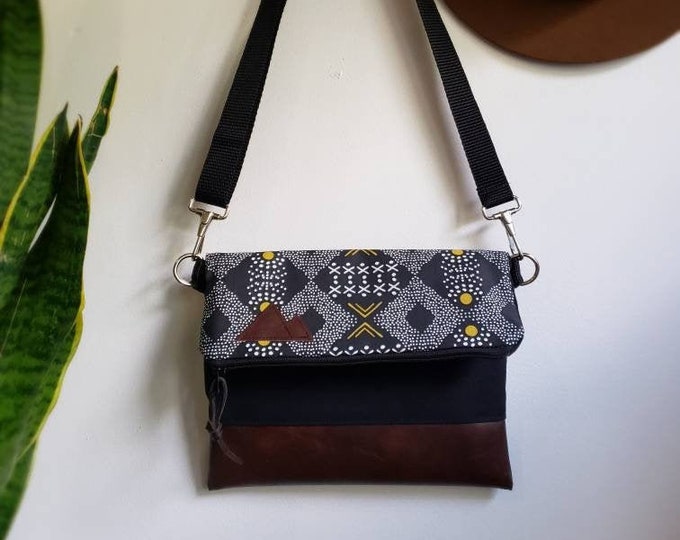 Foldover crossbody/Mud cloth print/Black zipper/Black canvas reverse/Black nylon adjustable strap/Mountain or Montana patch