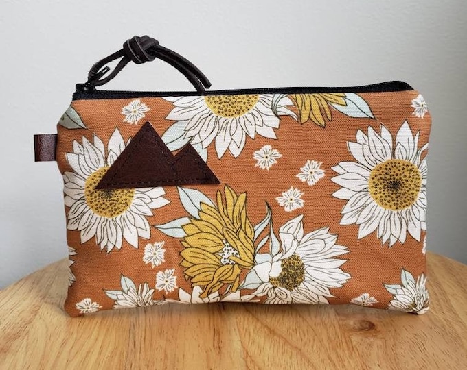 3 size options/Orange sunflower print = front and back/Natural canvas liner/Black zipper/Mountain or Montana patch