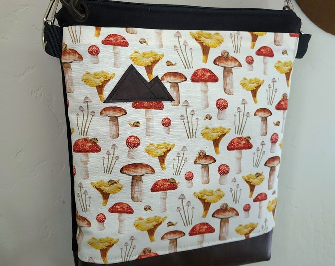 Medium crossbody/MUSHROOM print front = pocket/Black zip/Black canvas reverse/Black nylon adjustable strap/Mountain or Montana patch