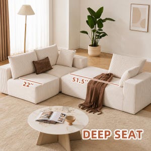 May include: A modular cream-colored corduroy sofa with a deep seat design. The sofa is composed of multiple sections, including a 22-inch wide piece and a 51.5-inch wide piece. It includes several matching throw pillows and a brown throw blanket.