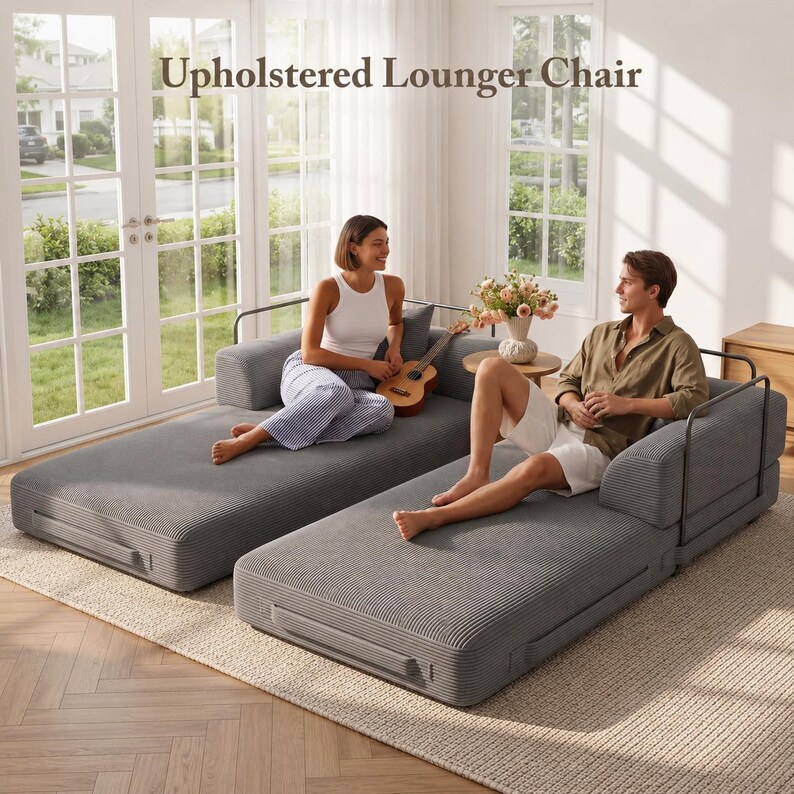 Puede incluir: Dos sillones reclinables tapizados grises con reposabrazos de metal negro. Las sillas est&aacute;n colocadas sobre una alfombra beige frente a una ventana. El texto "Upholstered Lounger Chair" est&aacute; en la parte superior de la imagen.