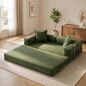May include: A modular, olive green sofa with a pull-out section. The sofa has a modern design with a metal frame and includes two square throw pillows. The sofa is placed on a light-colored rug in a well-lit room.