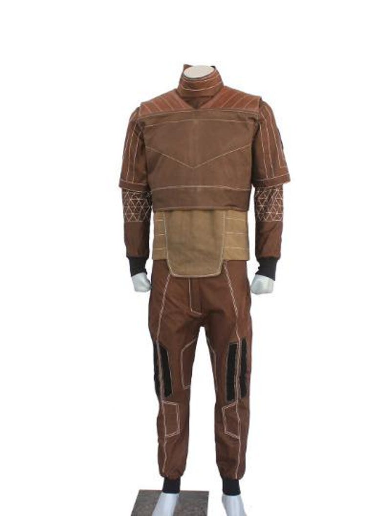 May include: A brown long-sleeved shirt and matching pants set featuring a high collar, white geometric stitching patterns on the sleeves, and a tan midsection panel. The pants include black vertical accents and white contrast stitching throughout.