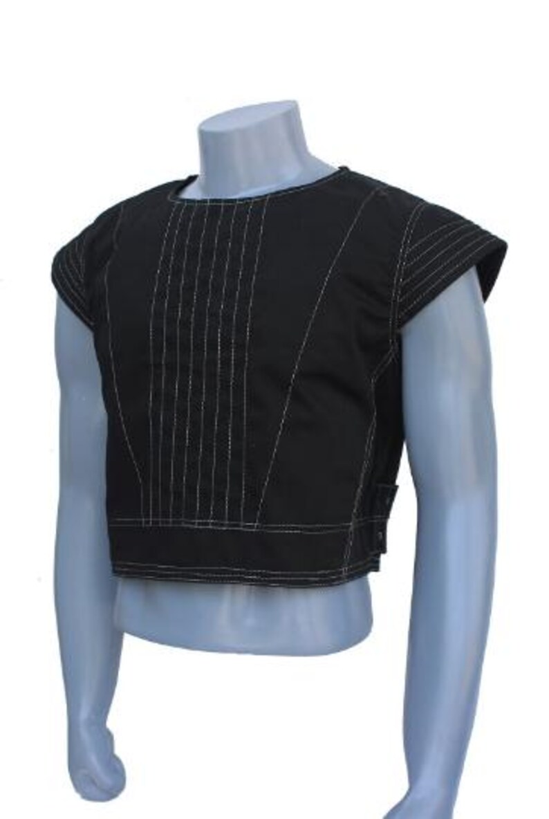 May include: A black cropped vest featuring a round neckline and short cap sleeves. The front panel is decorated with vertical white topstitching details. The garment has a horizontal band at the hem and side tabs with metal snap fasteners.