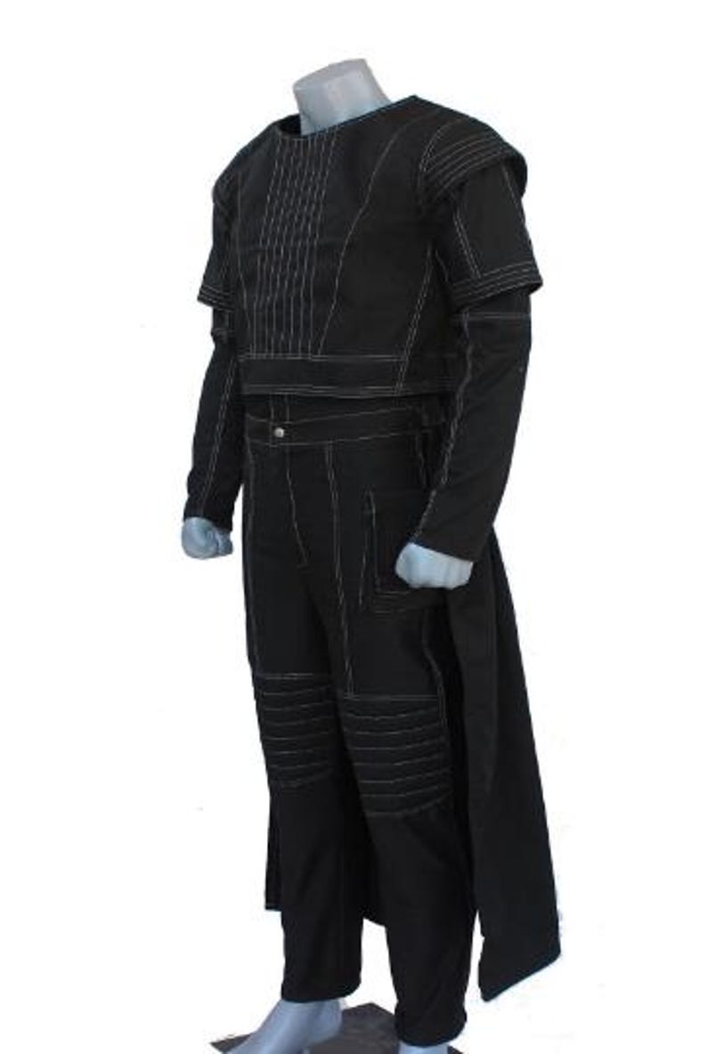 May include: A black costume set featuring a cropped top with vertical stitching and matching trousers with reinforced knee panels. The ensemble includes long sleeves, a high neckline, and a long back panel, all accented with prominent white topstitching.