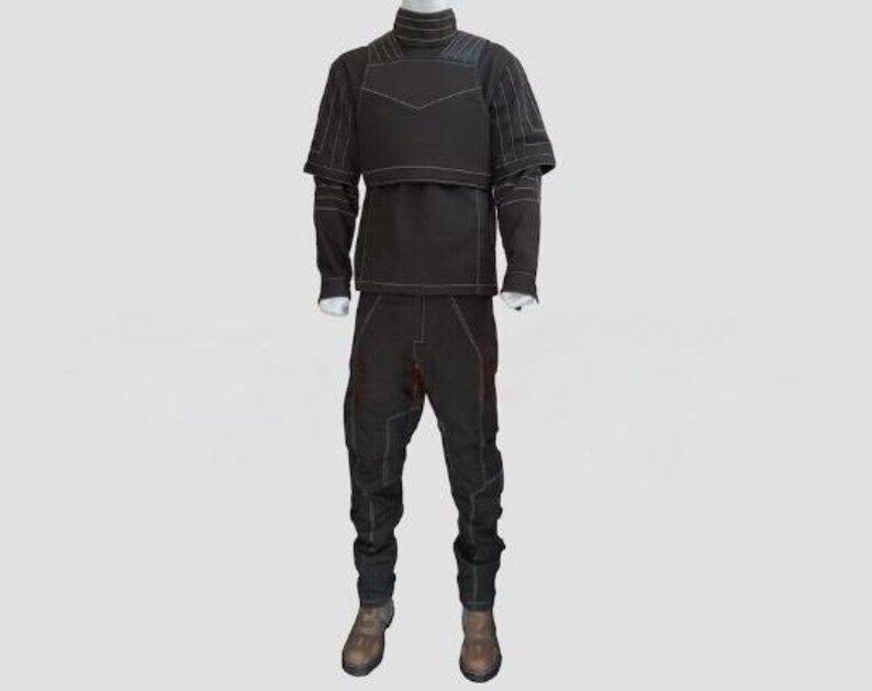 Peut inclure: Un ensemble noir compos&eacute; d'un haut &agrave; manches longues avec un col montant et un empi&egrave;cement structur&eacute; sur la poitrine, assorti d'un pantalon noir. L'ensemble pr&eacute;sente des surpiq&ucirc;res blanches apparentes formant un motif g&eacute;om&eacute;trique.