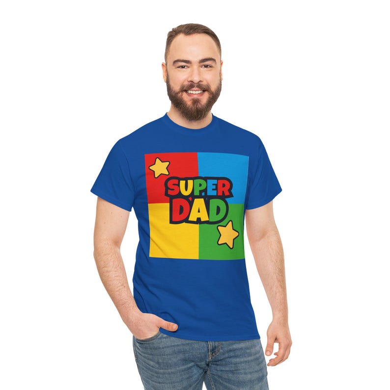 May include: Royal blue t-shirt with a colorful graphic that says "SUPER DAD". The graphic is divided into four squares of red, blue, yellow, and green, with yellow stars on either side of the text.