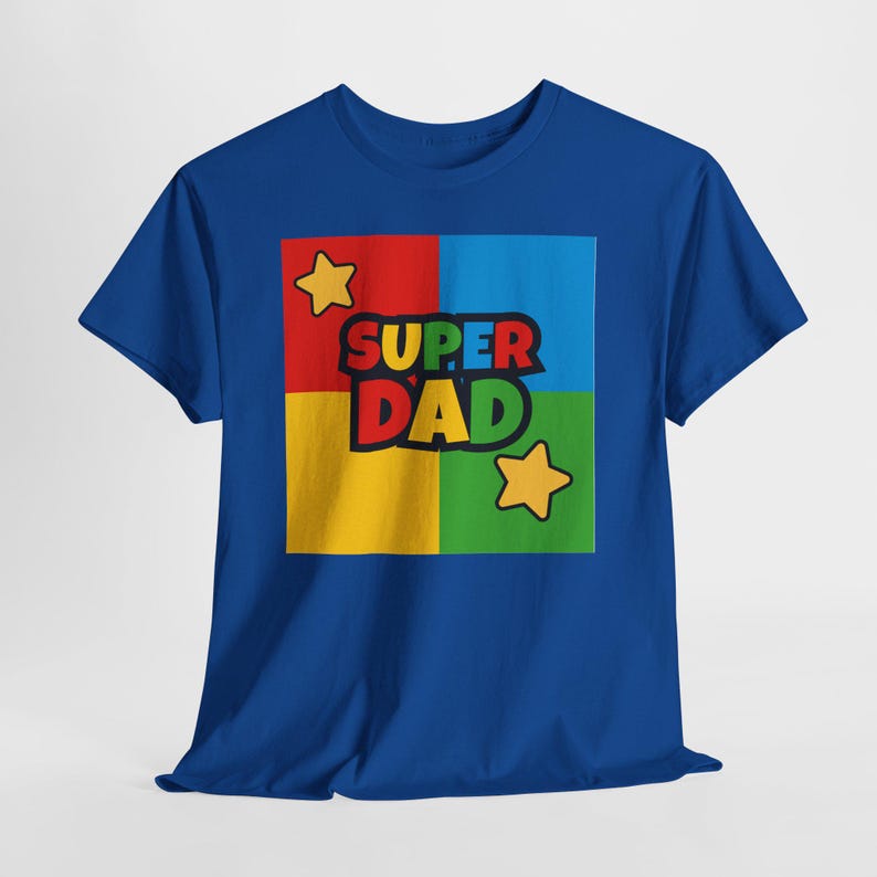 May include: Royal blue t-shirt with a colorful graphic that says "SUPER DAD". The graphic is in a square divided into four sections: red, blue, yellow, and green. Two yellow stars are also in the design.