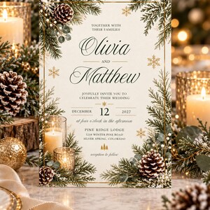 May include: A rectangular wedding invitation card with a cream background, featuring a gold border and a winter-themed frame of pine branches, pinecones, and gold snowflakes. The text reads: Together with their families, Olivia and Matthew, joyfully invite you to celebrate their wedding, December 12, 2027, at four o'clock in the afternoon, Pine Ridge Lodge, 1234 Winter Pine Road, Silver Spring, Colorado, reception to follow.