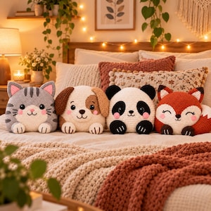 May include: Four crocheted plush toys shaped like animals sitting on a bed. The set includes a grey striped cat, a tan and white puppy, a black and white panda, and an orange and white fox, all featuring embroidered facial details and small paws.