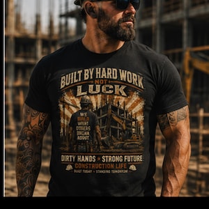 Puede incluir: Una camiseta negra con un estampado gráfico con el texto BUILT BY HARD WORK NOT LUCK, WE BUILD WHAT OTHERS DREAM ABOUT, DIRTY HANDS STRONG FUTURE, CONSTRUCTION LIFE y BUILT TODAY STANDING TOMORROW, que representa una escena de obra.