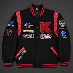 May include: A black varsity jacket with red leather shoulder panels and striped ribbed trim. The front features a large red letter K, the text Kavinsky, Plasma, Zenith, Renegade, Zombie, and Outsiders, along with various circular graphic patches.