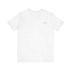 Pode incluir: Uma t-shirt branca de manga curta com um pequeno gráfico centrado na parte superior do peito. O gráfico consiste num símbolo de maior que em azul claro seguido da palavra code em letras minúsculas com um sublinhado no final.