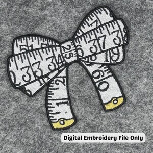 May include: A white and black embroidered patch shaped like a bow, constructed from a measuring tape pattern with visible numbers and black stitching. The ends of the bow feature small yellow accents. The text Digital Embroidery File Only is present.