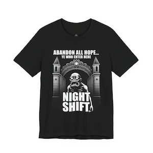 Peut inclure: T-shirt noir avec un graphisme représentant une figure de zombie devant une porte. Le texte dit "ABANDONNEZ TOUTE ESPÉRANCE... VOUS QUI ENTREZ ICI" au-dessus et "NIGHT SHIFT" en dessous.