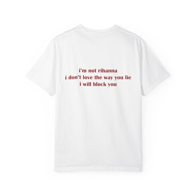 May include: A white short-sleeved t-shirt featuring dark red text printed on the back. The text reads: i'm not rihanna, i don't love the way you lie, i will block you. The garment has a crew neckline and a standard fit with short sleeves.