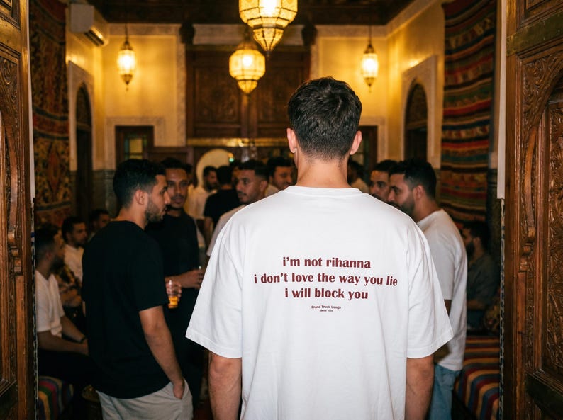 May include: A white short-sleeved t-shirt featuring dark red text on the back that reads: i'm not rihanna, i don't love the way you lie, i will block you. Below the text, smaller print reads: Brand Think Long, since 2024.