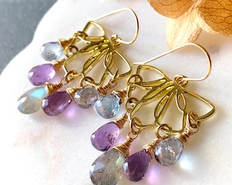 May include: Gold earrings with a delicate butterfly design and dangling amethyst, labradorite, and aquamarine gemstones.