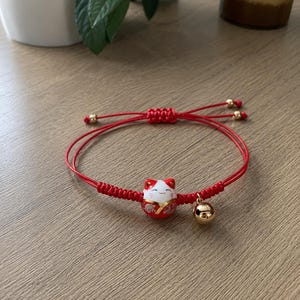 Pulseira Maneki Neko - amuleto da sorte, sorte e proteção.