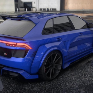 Può includere: Un'auto sportiva blu con ruote nere e uno spoiler posteriore. L'auto ha un design elegante e una targa. L'auto è parcheggiata su una superficie di asfalto bagnata.