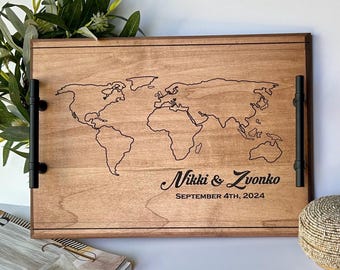 May include: A wooden serving tray with a world map engraved on the surface. The tray has black metal handles and the text "Nikki & Zvonko September 4th, 2024" is engraved below the map.