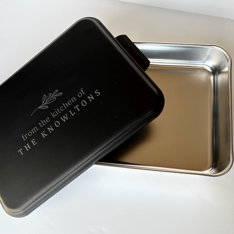 Może przedstawiać: Czarna forma do pieczenia z pokrywką. Pokrywka ma wygrawerowany napis "from the kitchen of THE KNOWLTONS".