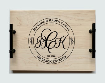 May include: A wooden serving tray with black metal handles. The tray has a circular design with the text "Brianna & Kaden Carlin" and "Rimrock Estates" along with the initials "BCK" and "Est. 2026".